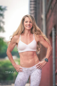 Mindy Self, a certified personal trainer, wearing a white top and leggings, posing for a photo.